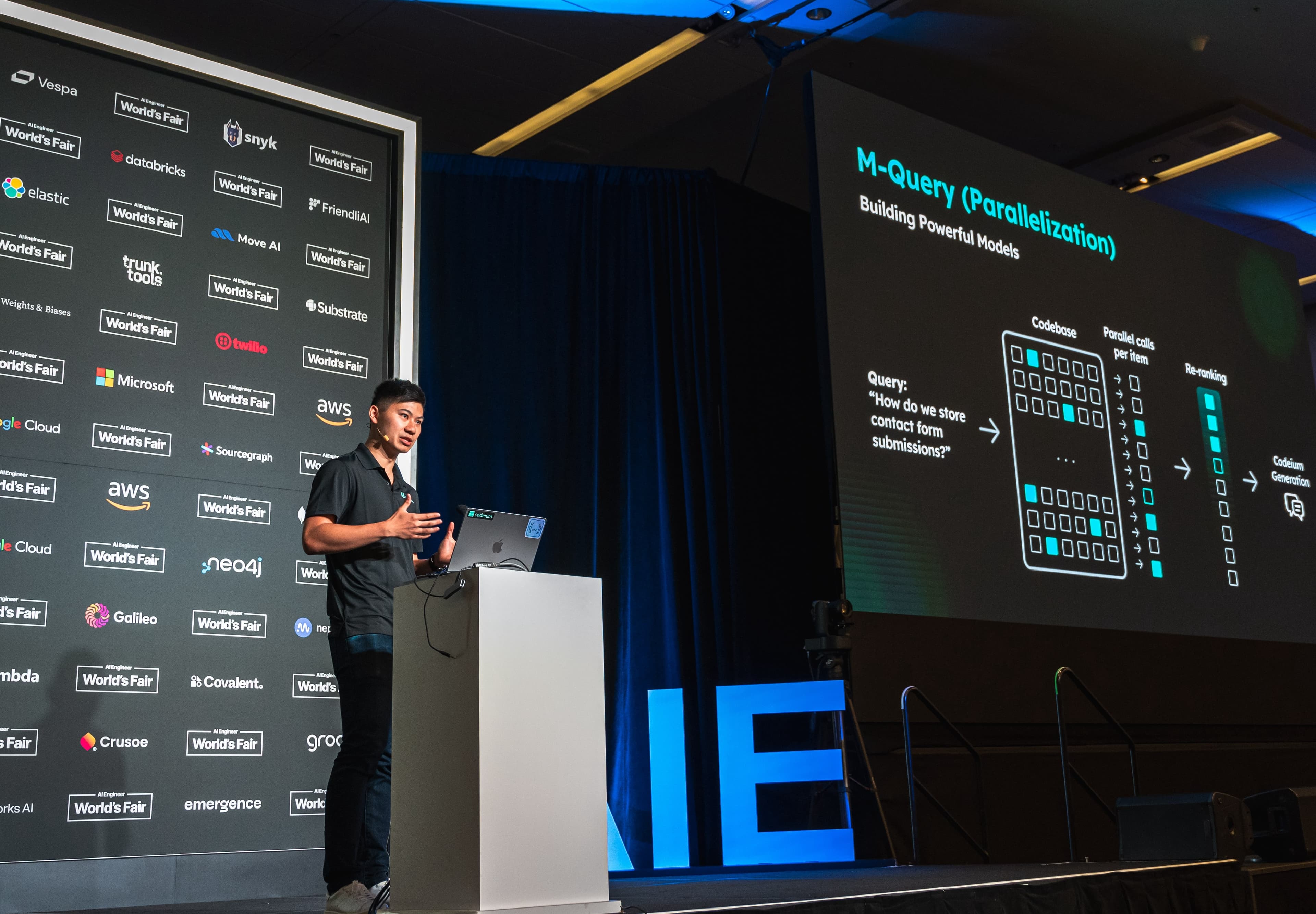 Kevin Hou presenting on a conference stage about M-Query Parallelization